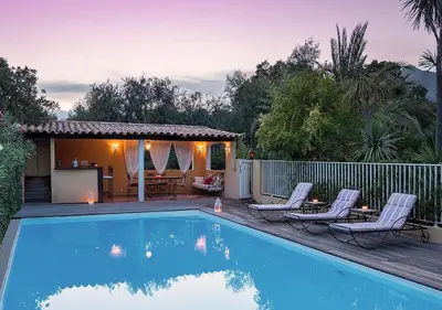 a swimming pool with two chairs and a house at Villa RUSCANA AVEC PISCINE PRIVÉE in Sainte-Lucie de Porto-Vecchio