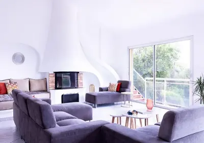 a living room with couches and a large window at Villa RUSCANA AVEC PISCINE PRIVÉE in Sainte-Lucie de Porto-Vecchio