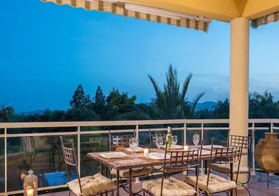 a table and chairs on a balcony with a view at Villa RUSCANA AVEC PISCINE PRIVÉE in Sainte-Lucie de Porto-Vecchio