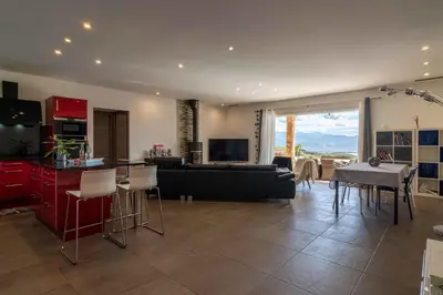 a kitchen and living room with a couch and a table at Villa vue mer 4 chambres in Olmeto