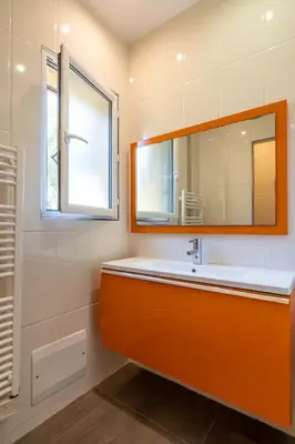 an orange bathroom with a sink and a mirror at Villa vue mer 4 chambres in Olmeto