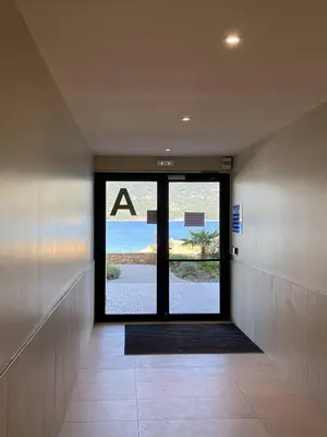 a hallway with a door with a view of the beach at Coté Plage pied dans l'eau vue mer in Propriano