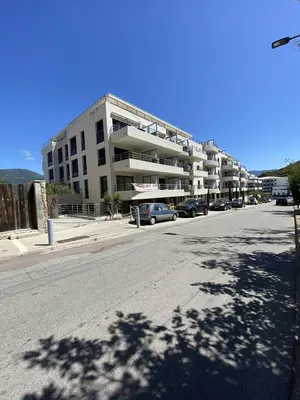 a parking lot with cars parked in front of a building at Coté Plage pied dans l'eau vue mer in Propriano
