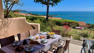 a table with food on it with a view of the ocean at Maison 4 pièces, vue panoramique, piscine, climatisation, près de Palombaggia in Porto-Vecchio