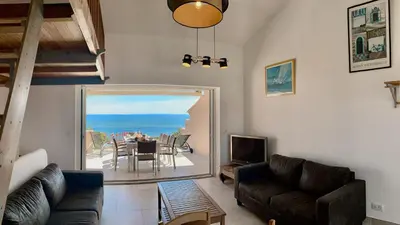a living room with a couch and a television and a table at Maison 4 pièces, vue panoramique, piscine, climatisation, près de Palombaggia in Porto-Vecchio