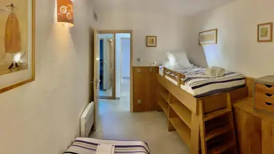 a bedroom with two bunk beds and a bathroom at Maison 4 pièces, vue panoramique, piscine, climatisation, près de Palombaggia in Porto-Vecchio