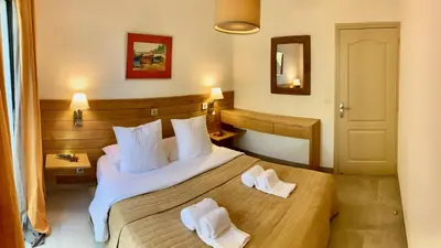 a hotel room with a bed with two towels on it at Maison 4 pièces, vue panoramique, piscine, climatisation, près de Palombaggia in Porto-Vecchio