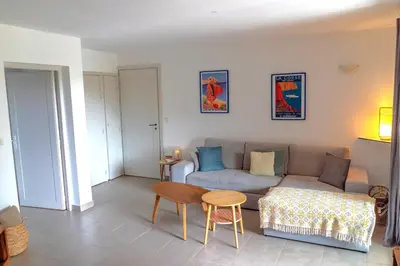 a living room with a couch and a table at Appartement Les Hameaux de Pinarello in Sainte-Lucie de Porto-Vecchio