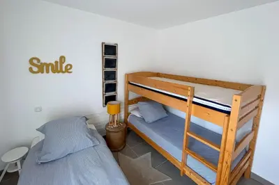 a bedroom with two bunk beds and a ladder at Appartement Les Hameaux de Pinarello in Sainte-Lucie de Porto-Vecchio