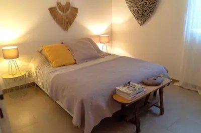 a bedroom with a bed with a table and two lamps at Appartement Les Hameaux de Pinarello in Sainte-Lucie de Porto-Vecchio