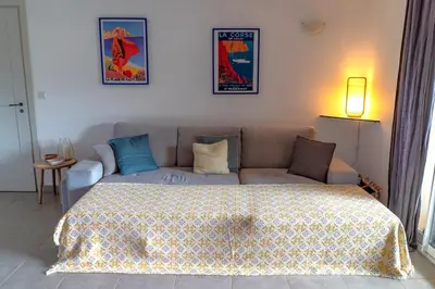 a living room with a couch and a bed at Appartement Les Hameaux de Pinarello in Sainte-Lucie de Porto-Vecchio