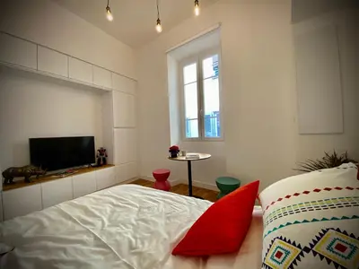 a bedroom with a bed and a tv and a window at Suite Letizia in Ajaccio