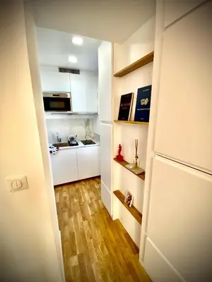 a small kitchen with white cabinets and wooden floors at Suite Letizia in Ajaccio
