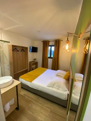 a bedroom with a bed and a bathroom with a sink at Hotel U Catagnu in San-Nicolao
