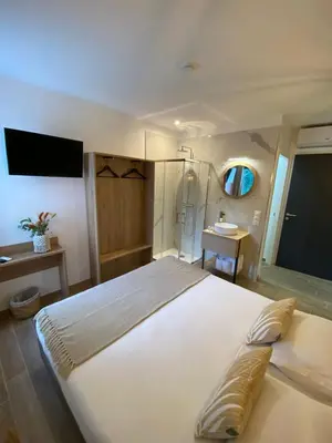 a bedroom with a large white bed and a sink at Hotel U Catagnu in San-Nicolao