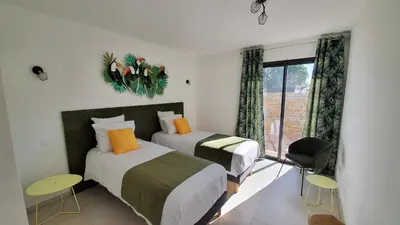 two beds in a room with a window at Villa Nananthée T5 de luxe,4-8 pers, piscine privée chauffée in Lecci