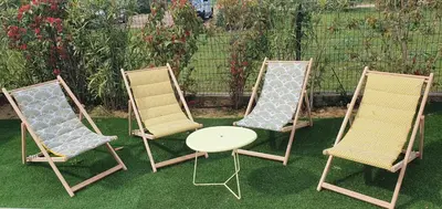 a group of three chairs and a table on the grass at Villa Nananthée T5 de luxe,4-8 pers, piscine privée chauffée in Lecci