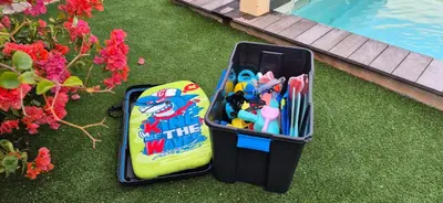 a suitcase sitting on the grass next to a pool at Villa Nananthée T5 de luxe,4-8 pers, piscine privée chauffée in Lecci