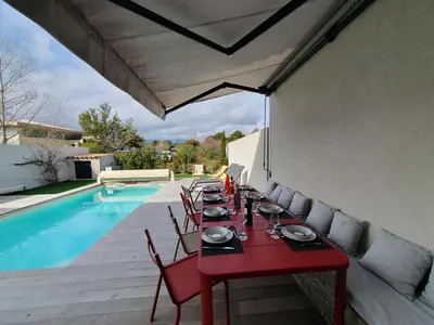 a red table and chairs next to a pool at Villa Nananthée T5 de luxe,4-8 pers, piscine privée chauffée in Lecci
