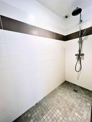 a bathroom with a shower with white tiles at Jardins de Quatrina centre ville in Propriano