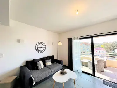 a living room with a couch and a table at Jardins de Quatrina centre ville in Propriano