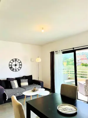 a living room with a couch and a table at Jardins de Quatrina centre ville in Propriano