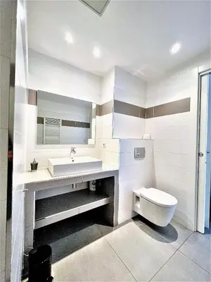 a bathroom with a white toilet and a sink at Jardins de Quatrina centre ville in Propriano