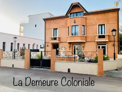 a house with a gate and a fence at Hôtel La Demeure Coloniale in Moriani Plage