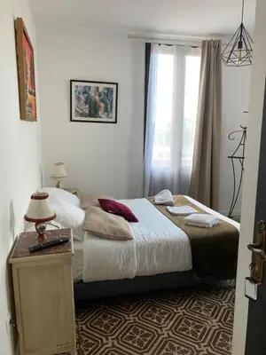 a small bedroom with a bed and a window at Hôtel La Demeure Coloniale in Moriani Plage
