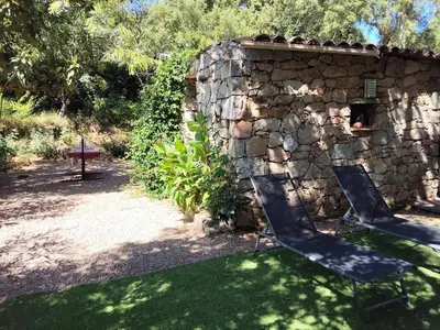 a stone wall with two chairs in a yard at Chalet Conca in Conca