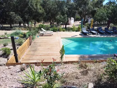 a wooden deck next to a swimming pool with chairs at Chalet Conca in Conca