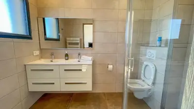 a bathroom with a sink and a toilet and a shower at Tres belle villa neuve vue mer avec piscine chauffee in Sainte-Lucie de Porto-Vecchio