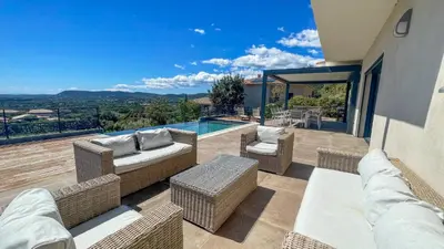 a patio with wicker furniture and a swimming pool at Tres belle villa neuve vue mer avec piscine chauffee in Sainte-Lucie de Porto-Vecchio