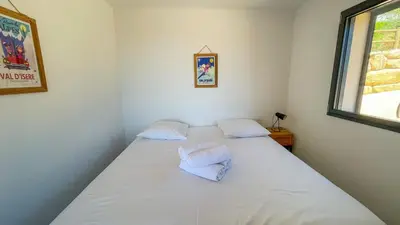 a bedroom with a bed with two pillows on it at Tres belle villa neuve vue mer avec piscine chauffee in Sainte-Lucie de Porto-Vecchio