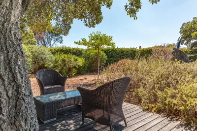 a table and chairs sitting on a wooden deck at Villa Calyaunati Di San Ciprianu in Lecci