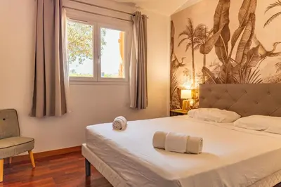 a bedroom with a bed with a window and a chair at Villa Calyaunati Di San Ciprianu in Lecci