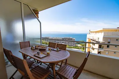 a table and chairs on a balcony with a view of the ocean at Cappella in Ajaccio
