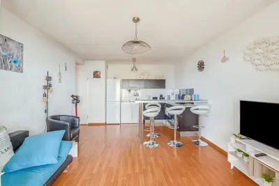 a living room with a blue couch and a kitchen at Cappella in Ajaccio