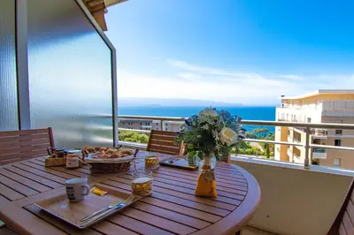 a table on a balcony with a view of the ocean at Cappella in Ajaccio