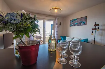 a table with wine glasses and a vase with flowers at Cappella in Ajaccio