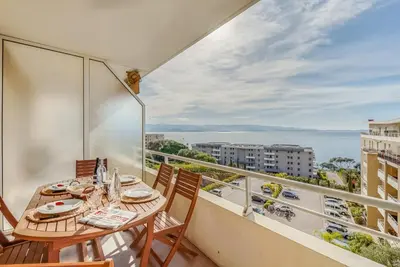a balcony with a table and chairs and a view of the ocean at Cappella in Ajaccio