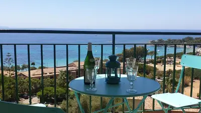 a table with a bottle of wine and glasses on a balcony at Santa Lina in Ajaccio