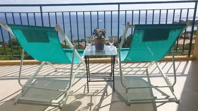 two chairs and a table on a balcony with the ocean at Santa Lina in Ajaccio