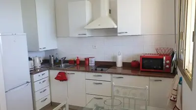 a kitchen with white cabinets and a red microwave at Santa Lina in Ajaccio