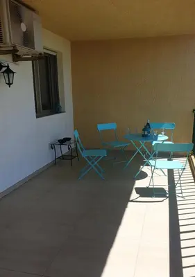a patio with a table and chairs in a room at Santa Lina in Ajaccio