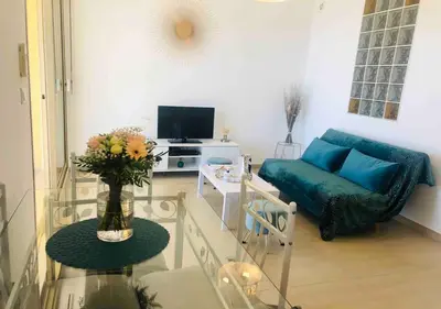 a living room with a blue couch and a tv at Santa Lina in Ajaccio