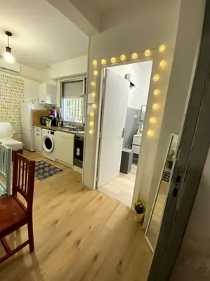a living room with a kitchen and a door with lights at studio cappella in Ajaccio