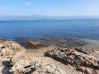 a beach with some rocks and the water at studio cappella in Ajaccio