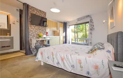 a bedroom with a large bed and a kitchen at Corse et Zen BULLE ZEN 25 m² 2 pers + Bébé in Folelli