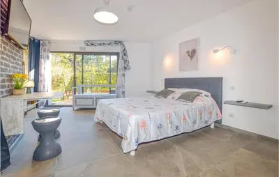 a bedroom with a bed and a desk and a window at Corse et Zen BULLE ZEN 25 m² 2 pers + Bébé in Folelli